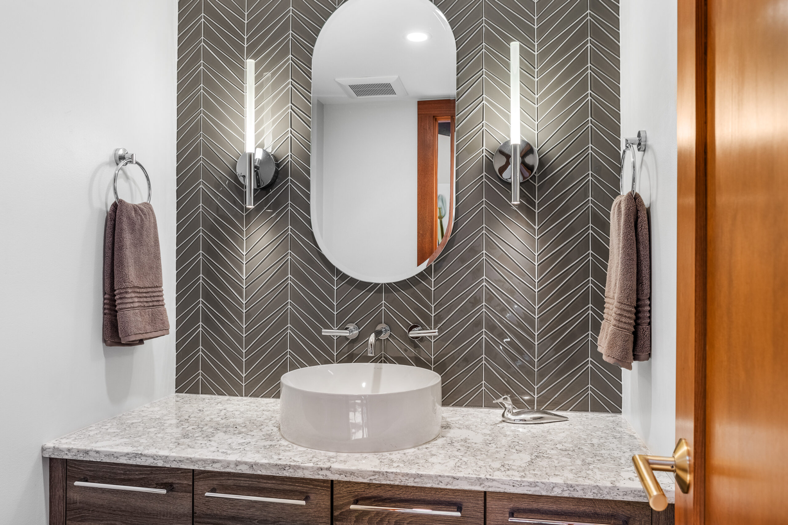 Grantham NH renovated bath with gray chevron tiles, white bowl sink and chrome finishes