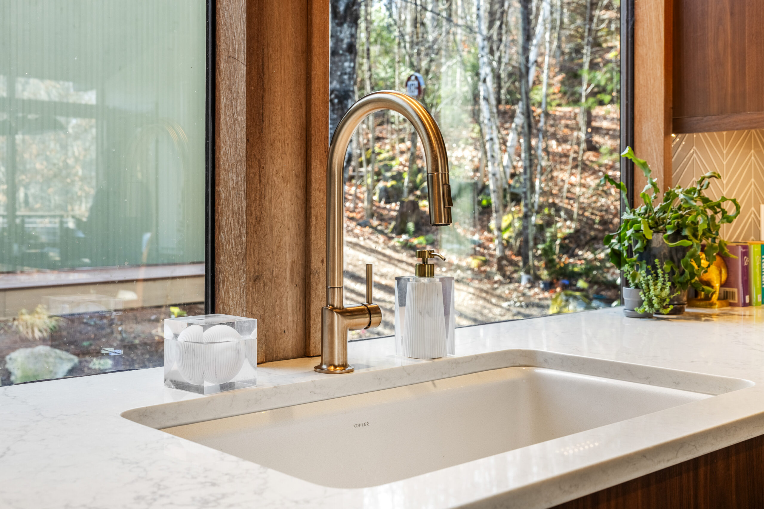 NH Kitchen sink with gold faucet, white sink and light stone countertop