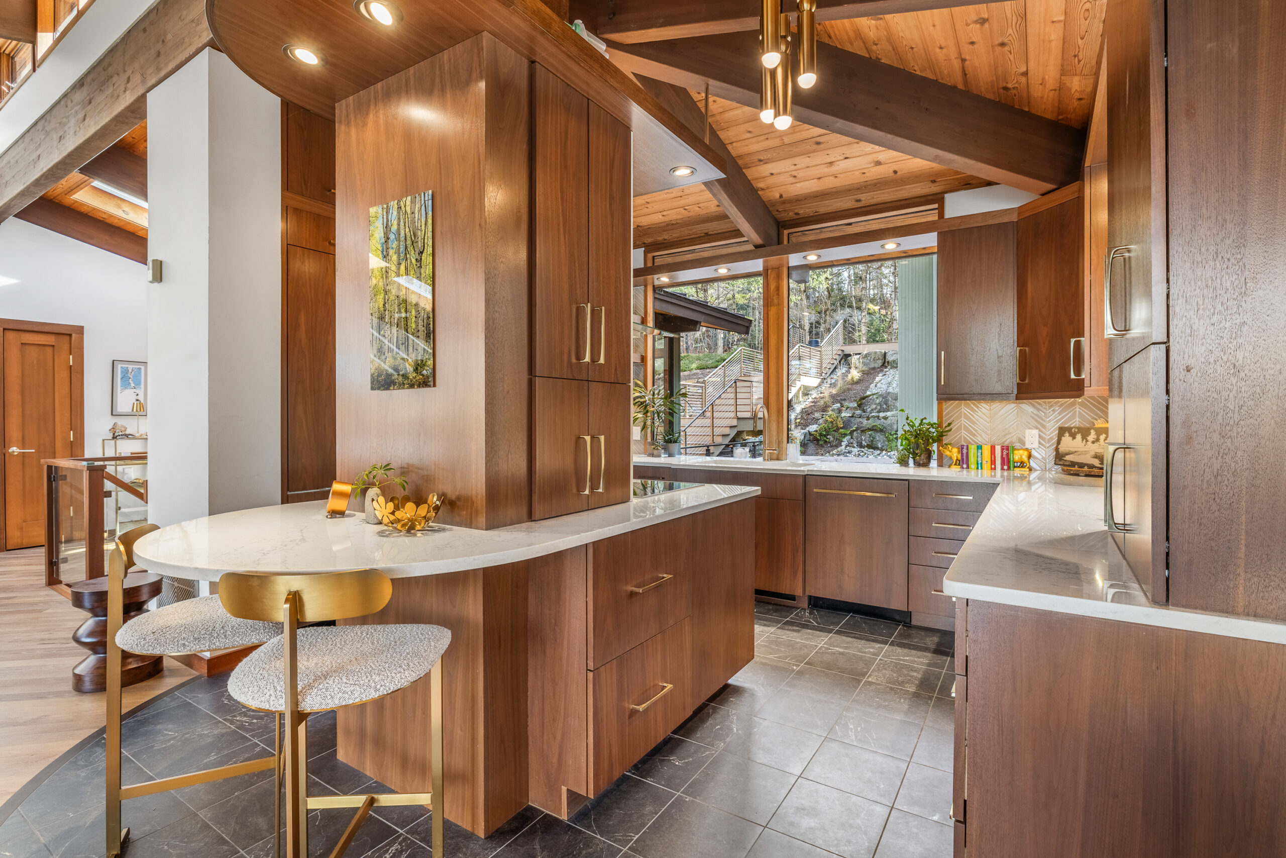 Grantham NH kitchen with dark wood cabinets, black tile floor, light countertops and gold finishes