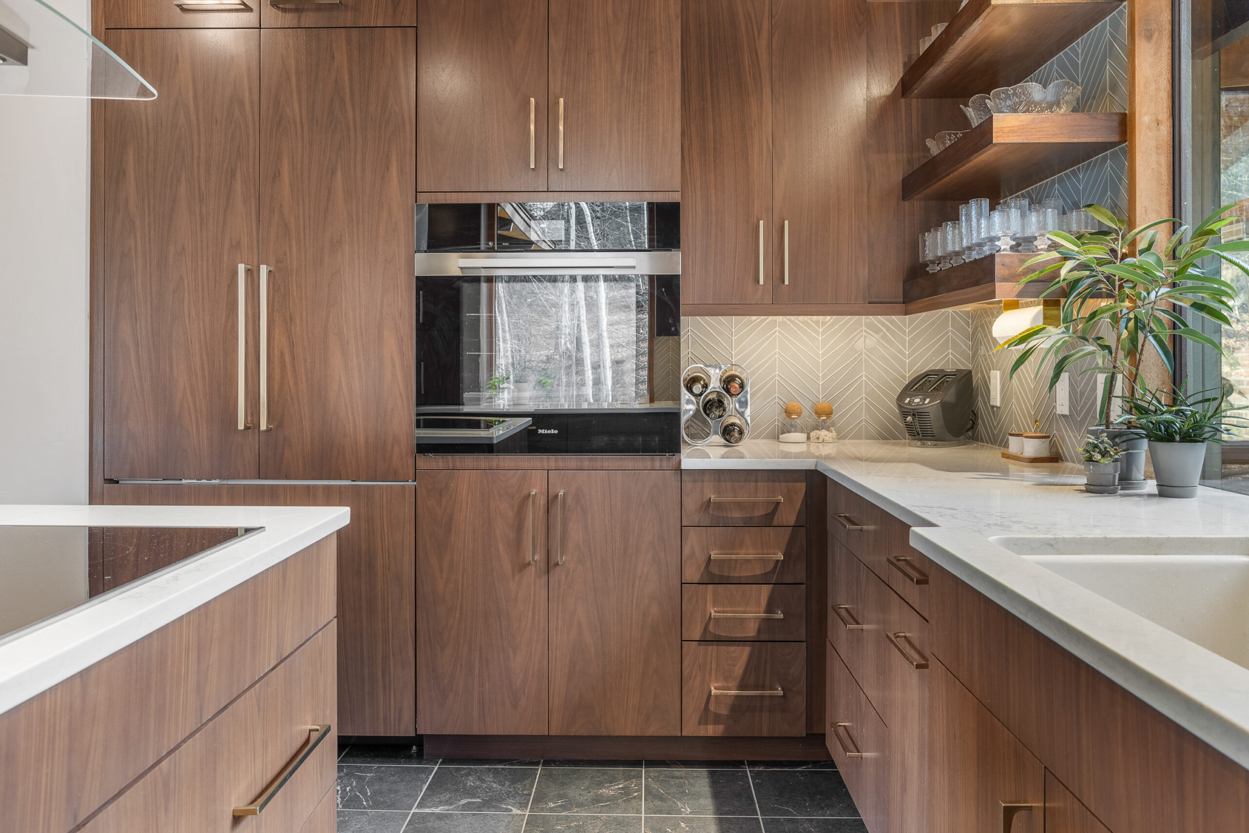 Custom dark wood cabinets with wall oven and gold handles